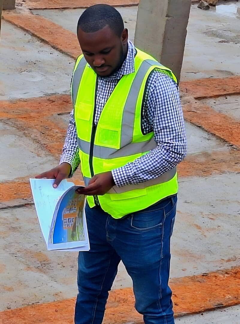 Site engineer reviewing architectural plans on site
