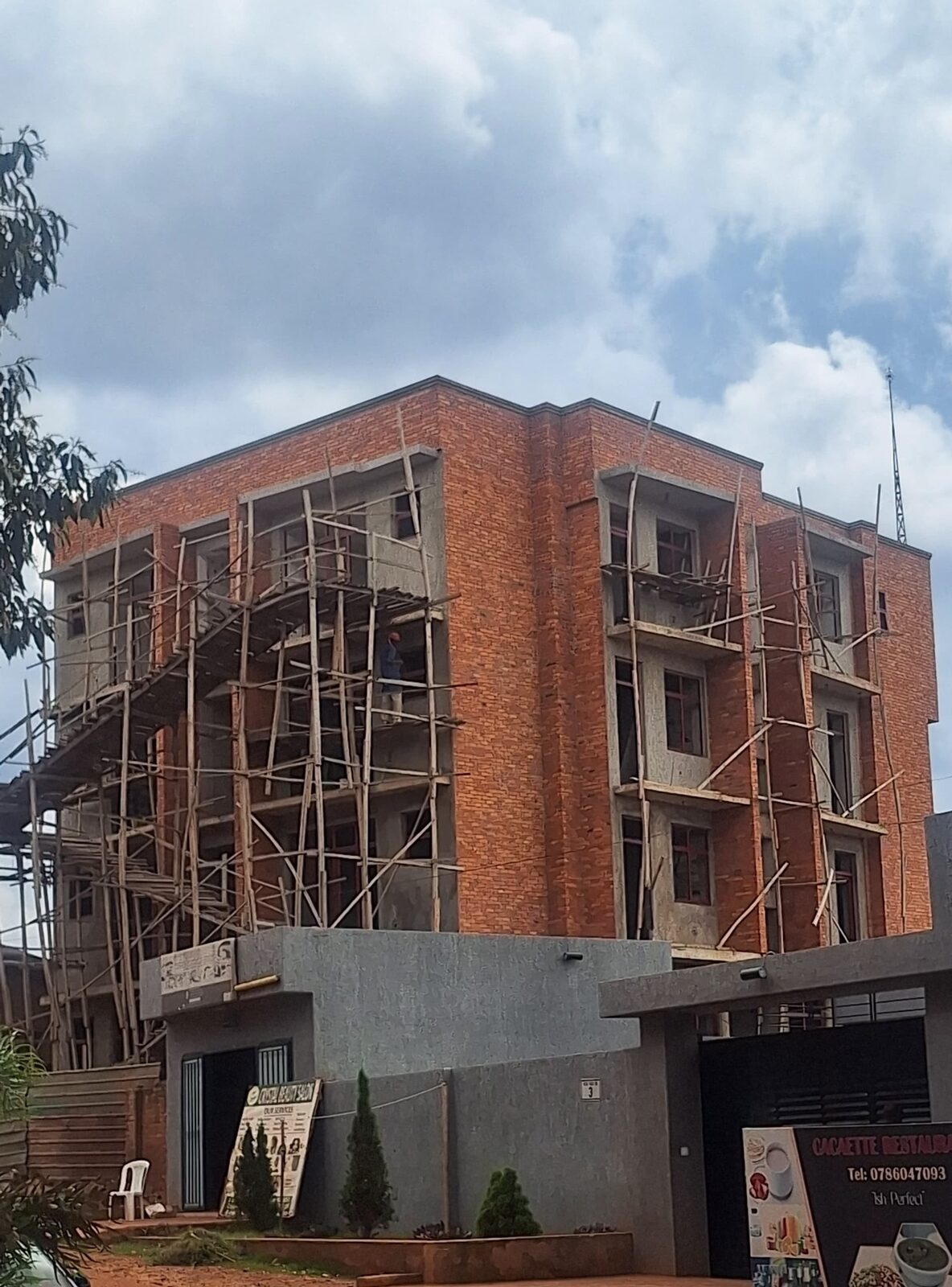 Multi-storey brick building under construction with scaffolding