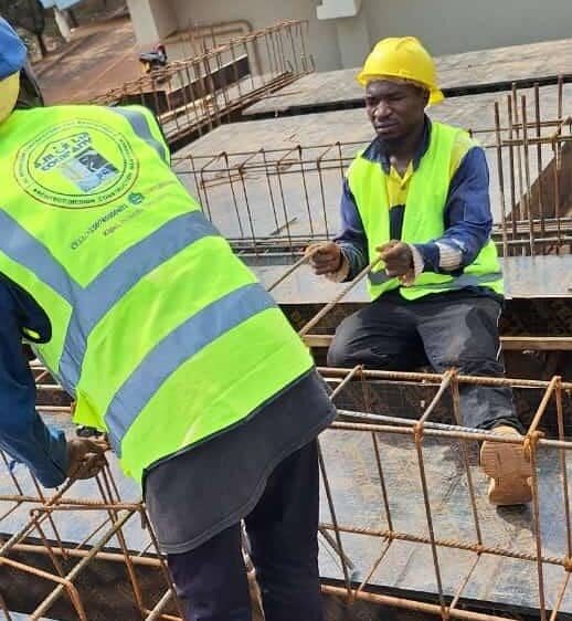 Workers tying rebar cage together on site