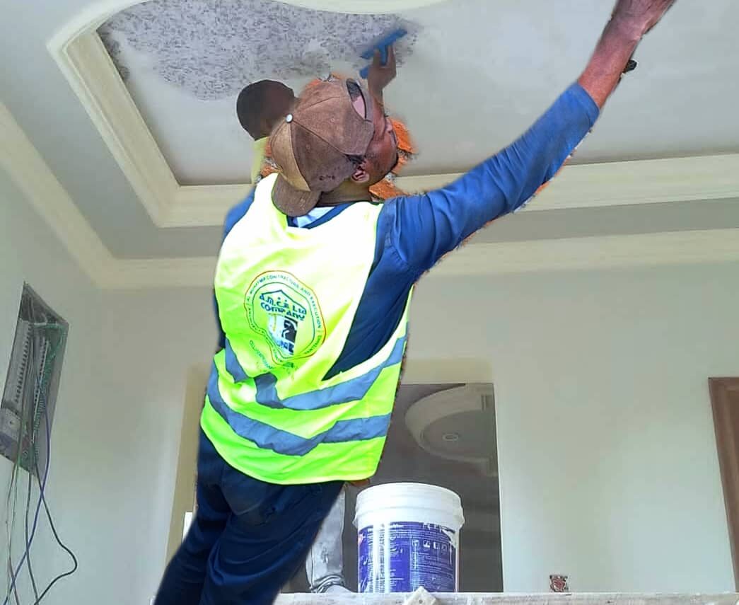 Worker applying finishing plaster to ceiling molding