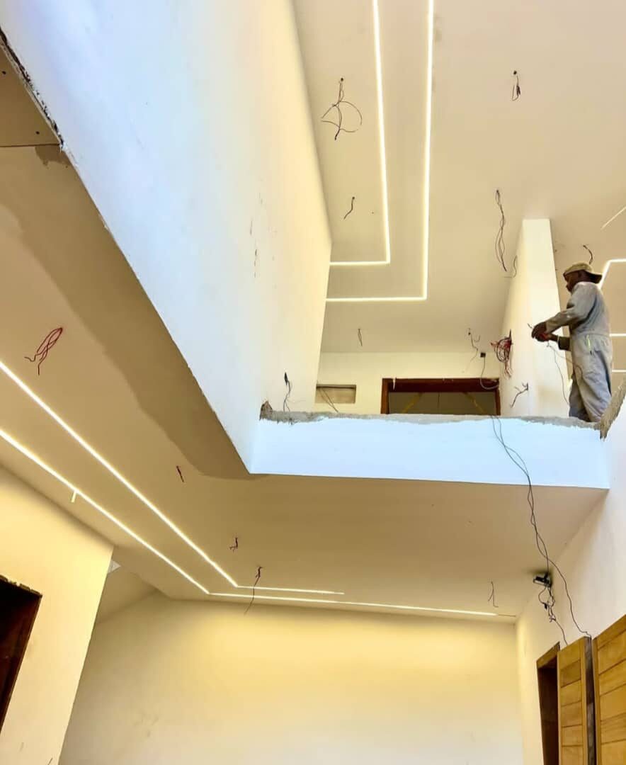 Worker installing recessed LED ceiling lighting