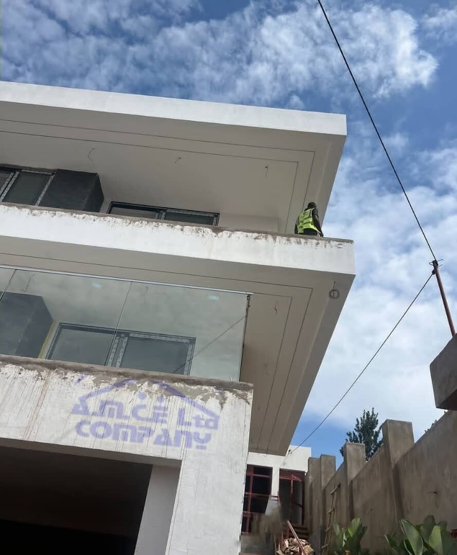 Worker on rooftop balcony of AMCE Ltd building