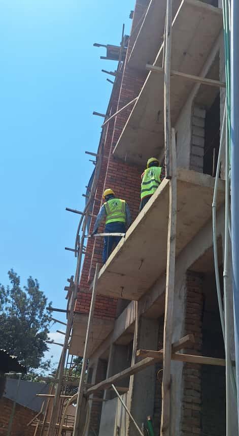 Workers on scaffolding at brick apartment building