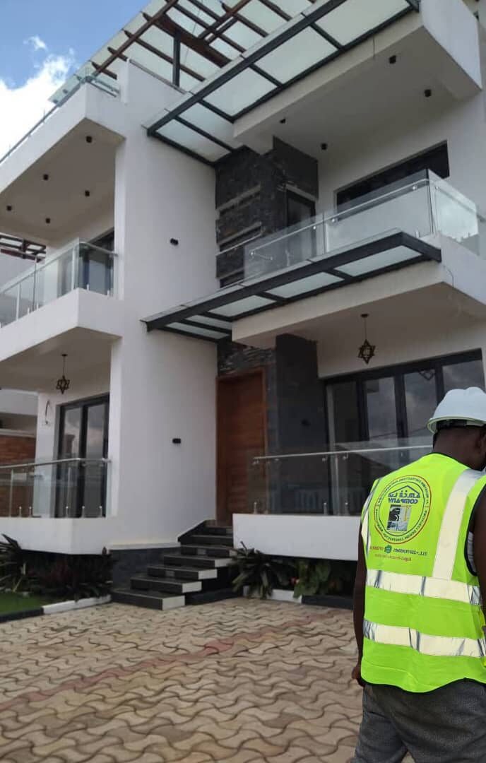 Site engineer inspecting finished luxury villa exterior